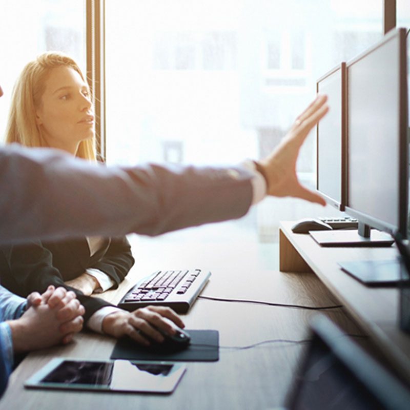 SEO company looking at computer explaining strategy.