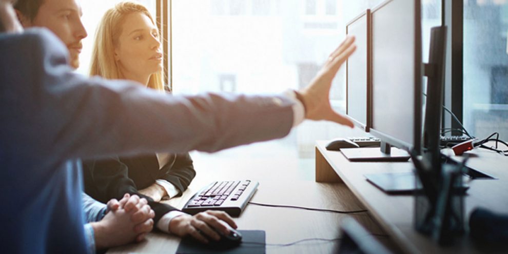 SEO company looking at computer explaining strategy.