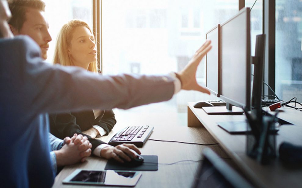 SEO company looking at computer explaining strategy.